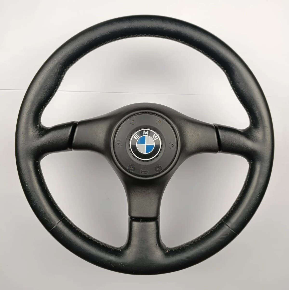 Nardi BMW Blackline steering wheel — black leather 3-spoke with BMW roundel horn pad, KBA 70183